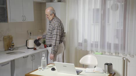Anciano-Feliz-Usando-Una-Computadora-Portátil-En-La-Cocina.